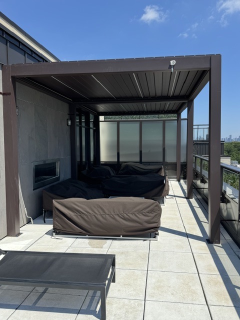 Rooftop pergola lounge with outdoor fireplace and sectional seating
