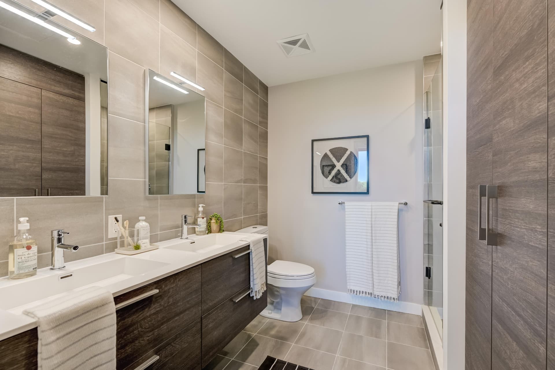 Four-piece ensuite with double vanity, tiled walls and glass shower