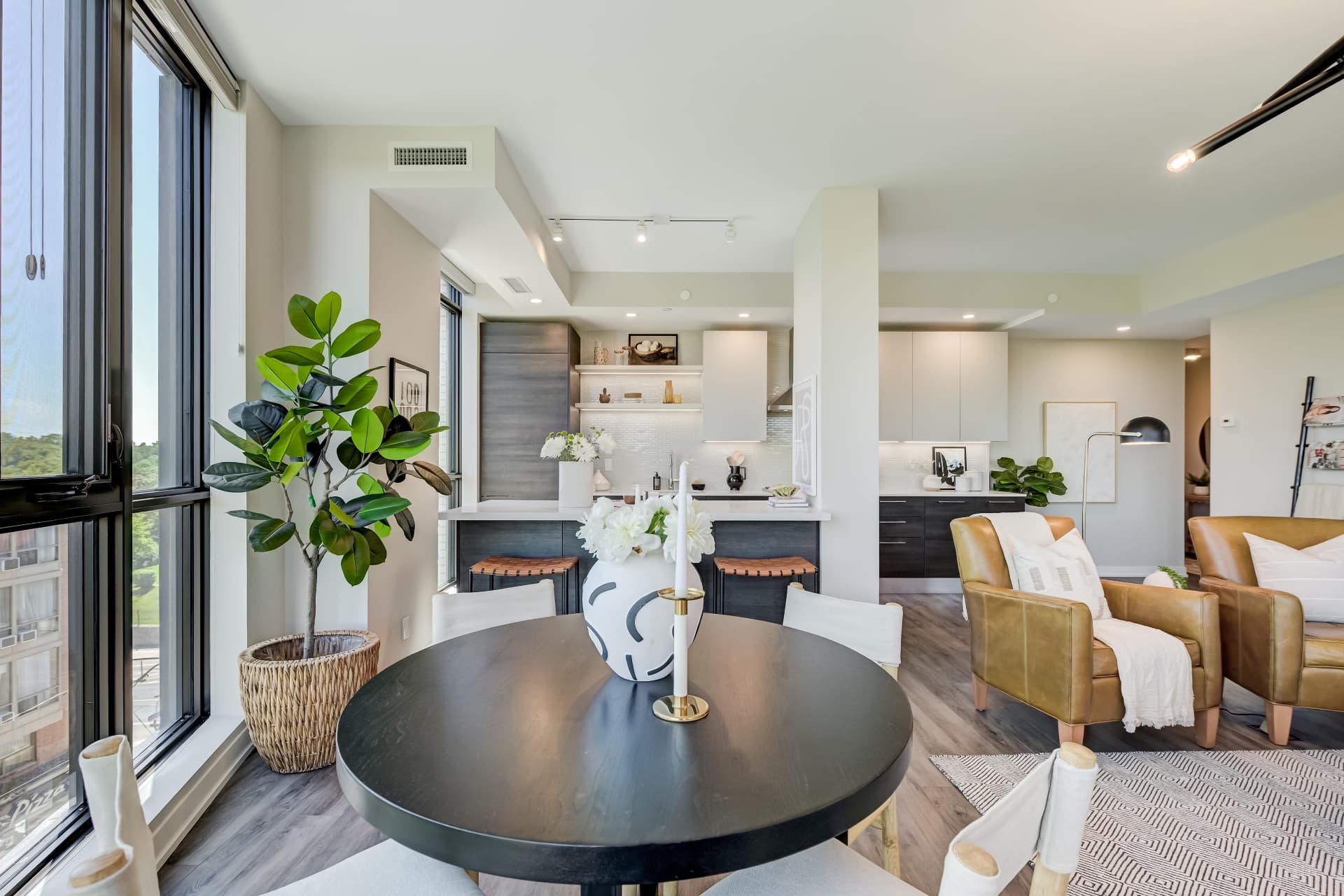 Dining area with tall windows and view into the kitchen