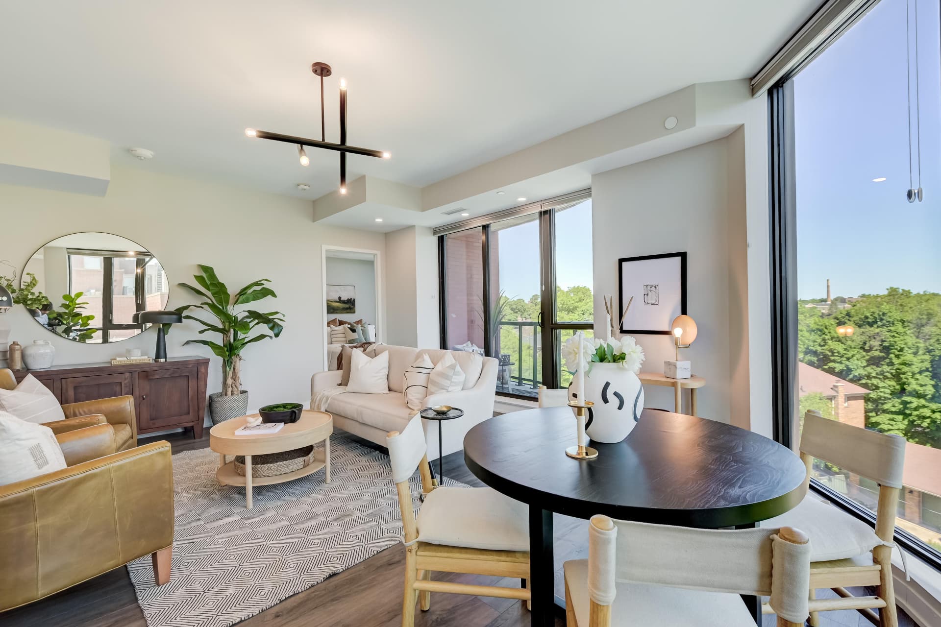 Living and dining areas with corner windows and balcony walkout