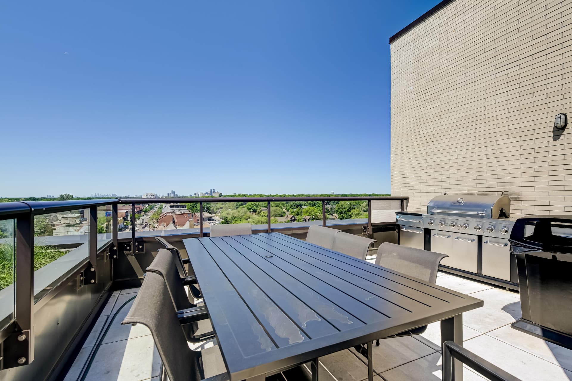 Rooftop dining area with BBQs overlooking Bloor St W