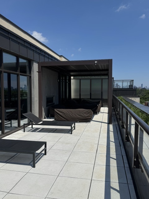 Rooftop terrace with loungers, pergola lounge and skyline beyond