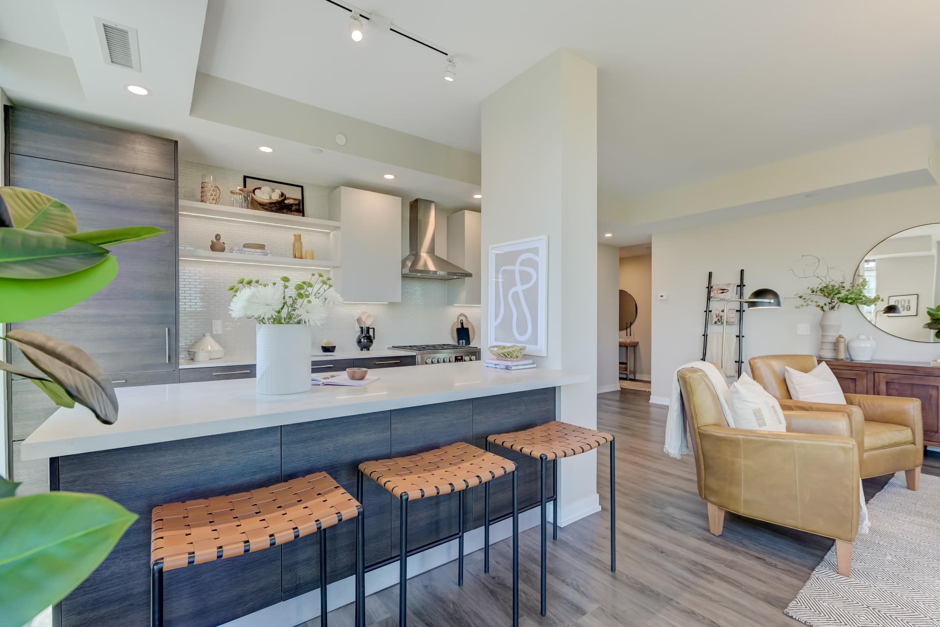Kitchen and breakfast bar with leather barstools beside the living room