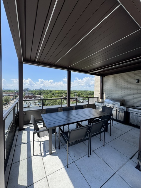 Covered rooftop dining area with BBQs and treetop views